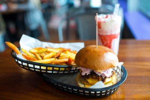 De er berømte burgerne fra Almost Famous. Her en Triple Nomnom med pommes frites av vanlige poteter og søtpoteter, samt en heftig jordbærmilkshake.